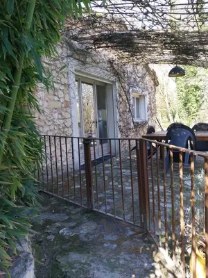 a fence in front of a house with a door at maison près de l'eau in LʼIsle-sur-la-Sorgue