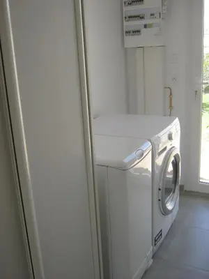 a washing machine in a kitchen with a refrigerator at Le Jardin des Tourterelles in Robion en Luberon