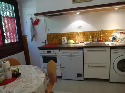 a kitchen with a stove and a sink and a table at Apartment Les Muriers Blancs in Aix-en-Provence