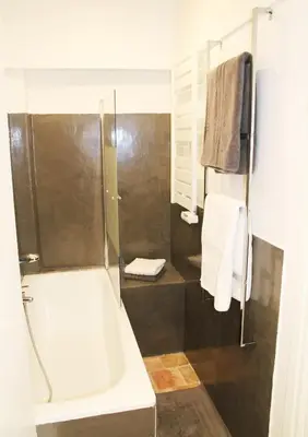 a bathroom with a tub and a shower with towels at Appartement coeur historique Aix in Aix-en-Provence