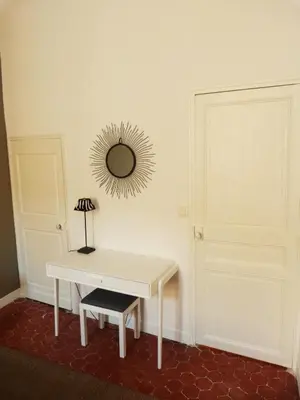 a table with a lamp and a mirror on a wall at Appartement coeur historique Aix in Aix-en-Provence