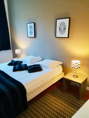 a bedroom with a bed and a night stand with a lamp at Appartement coeur historique Aix in Aix-en-Provence