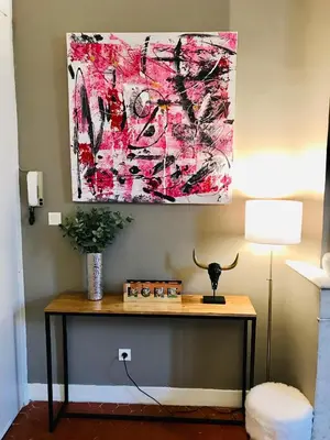 a table in a room with a painting on the wall at Appartement coeur historique Aix in Aix-en-Provence