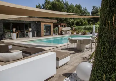 a backyard with a pool and a table and chairs at Mas des Cigales in Eygalières