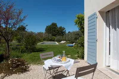 a table and chairs sitting on a gravel patio at Chambre d'hôtes le Mirail in La Motte-dʼAigues