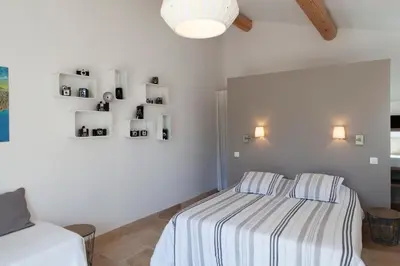 a bedroom with a bed with a striped blanket at Chambre d'hôtes le Mirail in La Motte-dʼAigues