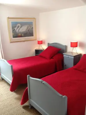 two beds in a room with red sheets and lamps at Domaine Saint Jean in Saint-Saturnin-les-Apt
