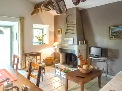 a living room with a fireplace and a table at Maison charmante à Oppède avec piscine partagée in Oppède