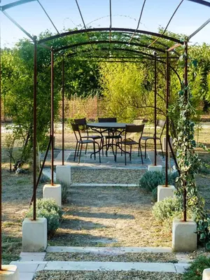 a pergola with a table and chairs under it at Maison charmante à Oppède avec vue sur la montagne in Oppède