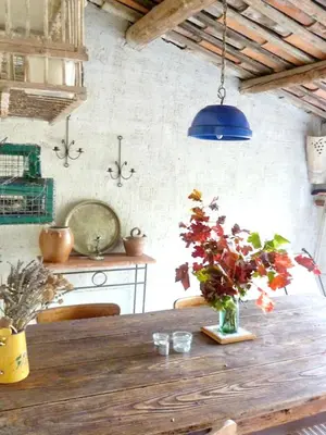 a dining room table with a vase of flowers on it at Appartement accueillant avec piscine à Oppède 70 m², vue montagne in Oppède