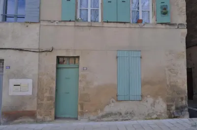 an old building with blue doors and windows at Appartement le Platane in Pertuis