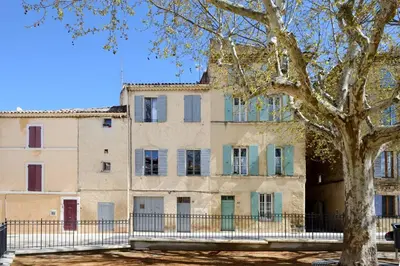an old building with a tree in front of it at Appartement le Platane in Pertuis