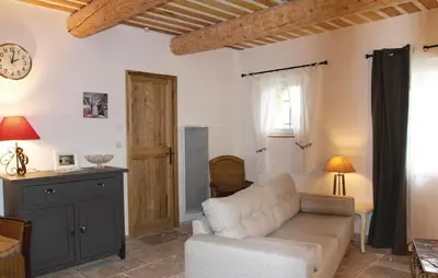 a living room with a couch and a clock on the wall at Cozy Home In Pernes Les Fontaines in Pernes-les-Fontaines