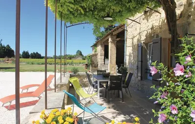 a patio with chairs and a table in front of a building at Cozy Home In Pernes Les Fontaines in Pernes-les-Fontaines