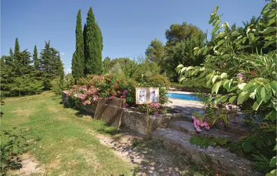 a garden with a swimming pool and flowers at Awesome Home In Crillon Le Brave in Crillon-le-Brave