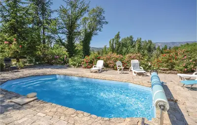 a swimming pool with two chairs and a table at Amazing Home In Crillon Le Brave in Crillon-le-Brave