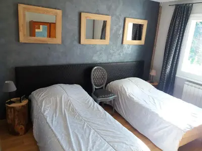a bedroom with two beds and a chair and pictures on the wall at Maison de charme avec piscine privée à Velleron in Velleron