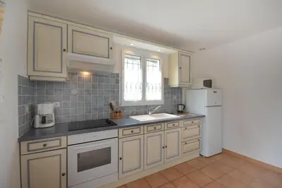 a kitchen with white cabinets and a white refrigerator at Cerise en Provence in Venasque
