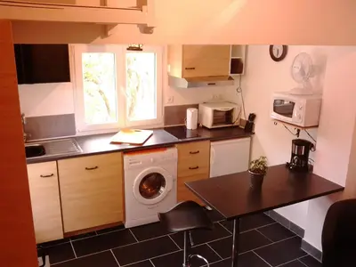 a kitchen with a washing machine and a microwave at Les Florides in LʼIsle-sur-la-Sorgue