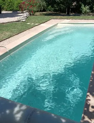a swimming pool with blue water in a yard at Le Petit Mas des Hauts de Beyssan, Maison de vacances avec piscine privative pour 2 personnes in Gargas