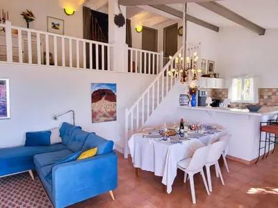 a dining room with a table and a blue couch at Sunny Provence Getaway in Villes-sur-Auzon
