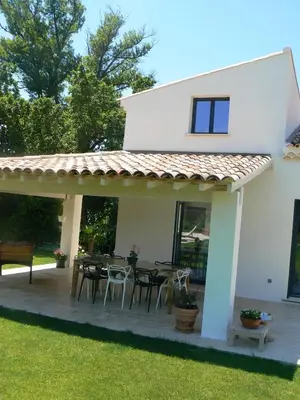 a patio with a table and chairs in front of a house at Villa charmante à Eyragues avec piscine privée in Eyragues