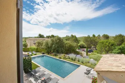 a swimming pool with chaise lounge chairs next to a yard at Villa Briali Pont Royal in Mallemort