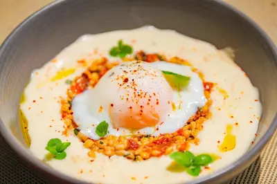 a bowl of food with a poached egg and beans at Château de Mazan - Handwritten Collection in Mazan