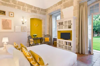 a bedroom with a large bed and a tv at Château de Mazan - Handwritten Collection in Mazan
