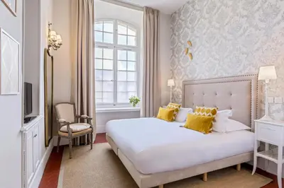 a bedroom with a large white bed with yellow pillows at Château de Mazan - Handwritten Collection in Mazan
