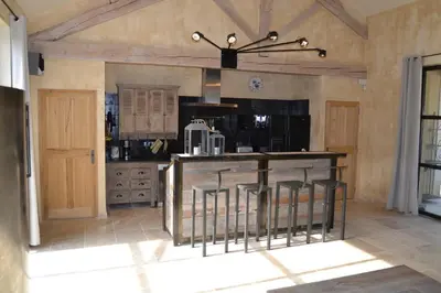 a kitchen with a island with bar stools at Mas Ste Hélène in Céreste
