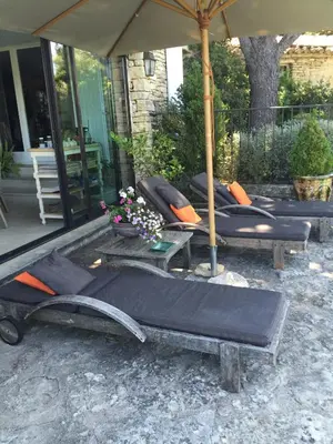 a group of lounge chairs sitting under an umbrella at La Borie en Provence in Gordes