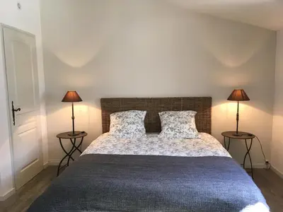 a bedroom with a large bed with two lamps at Le Petit Bastidon - Private pool - Gordes in Gordes