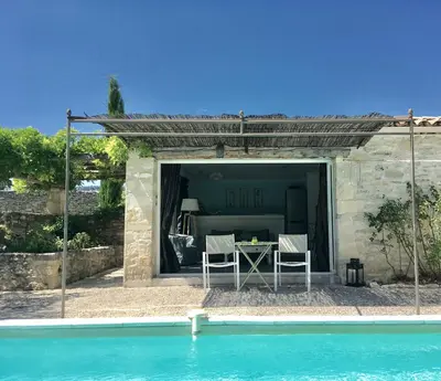 a patio with a table and chairs next to a pool at Le Petit Bastidon - Private pool - Gordes in Gordes