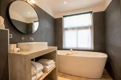 a bathroom with a tub and a sink and a mirror at Domaine la Pierre Blanche in Eygalières