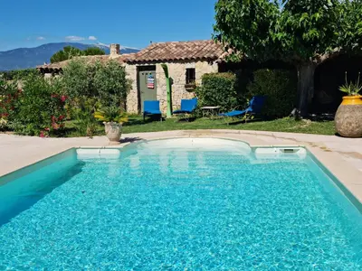 two chairs and a table next to a pool at Petit gite de Provence in Mazan