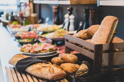 a buffet of bread and pastries on a table at Campanile Prime - Aix-en-Provence Sud - Pont de l'Arc in Aix-en-Provence