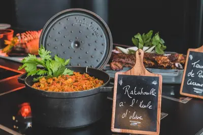 a table topped with a pot of food and signs at Campanile Prime - Aix-en-Provence Sud - Pont de l'Arc in Aix-en-Provence