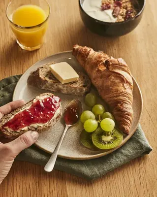 a plate of food with bread and grapes and cheese at Campanile Prime - Aix-en-Provence Sud - Pont de l'Arc in Aix-en-Provence