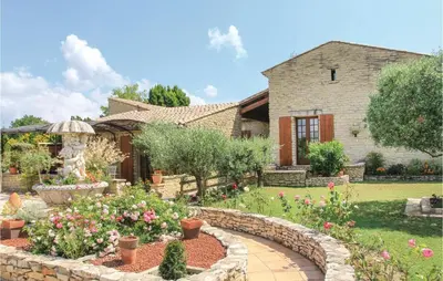 a garden in front of a house with flowers at 3 Bedroom Stunning Home In Gordes in Gordes