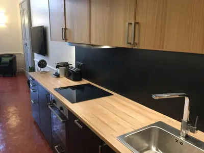 a kitchen with a sink and a wooden counter top at Les Suites du Cours & Spa in Aix-en-Provence