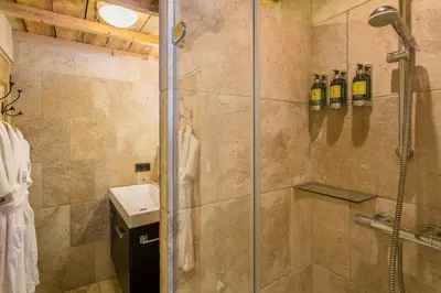a shower with a glass door in a bathroom at Domaine Les Roullets in Oppède