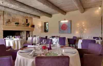 a dining room with white tables and purple chairs at Hôtel Restaurant Mas de Fauchon - Teritoria in Saint-Cannat