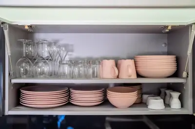a shelf filled with plates and glassware in a kitchen at Appart Hypercentre CLIM 2chb QuartierChic in Aix-en-Provence