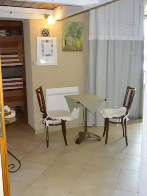 a room with two chairs and a desk and a table at Chambre d'hôte Anais in Eyguières