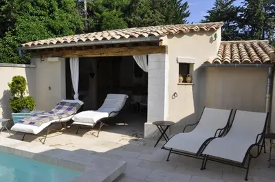 a patio with chairs and a swimming pool at Chambre d'hôte Anais in Eyguières