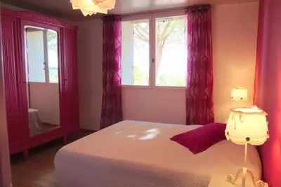 a bedroom with a bed with red curtains and a window at Que Passion in Blauvac