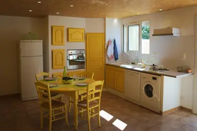 a kitchen with a table and a kitchen with yellow cabinets at Que Passion in Blauvac
