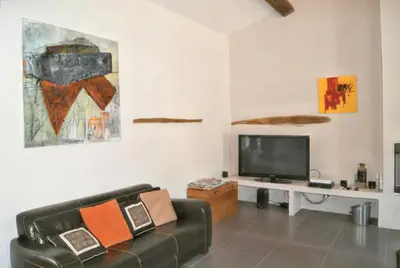 a living room with a couch and a tv at Villa spacieuse à Oppède avec piscine et vue imprenable in Oppède