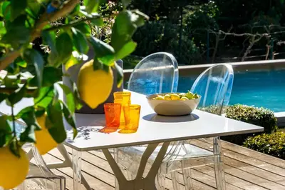 a table with a bowl of fruit and two chairs at BB 12 LUBERON chambres d'hôtes contemporaines in Gordes